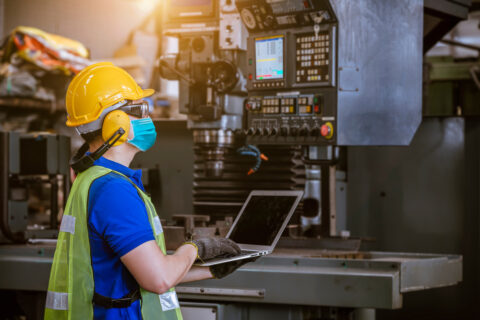 How to improve occupational hygiene - Industrial woman worker assessing a piece of machinery.