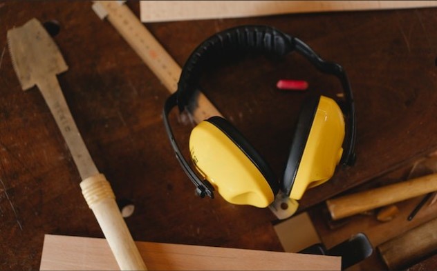 reducing exposure to noise in the workplace - carpenters ear protection on a wooden desktop