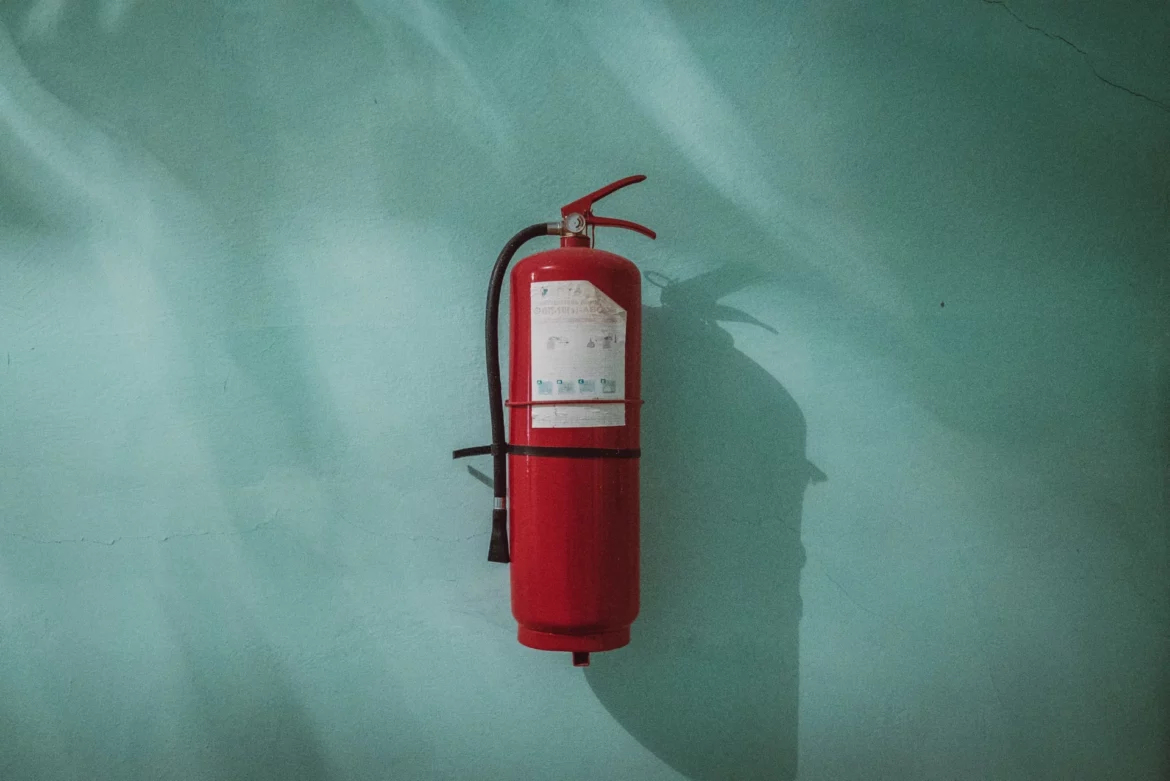 The role of employee participation in promoting and maintaining workplace safety and health - fire extinguisher hanging on wall