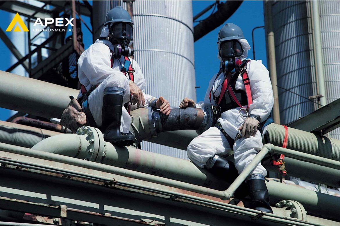 Workers in full protective gear inspecting industrial pipes, demonstrating safety protocols taught in asbestos training courses