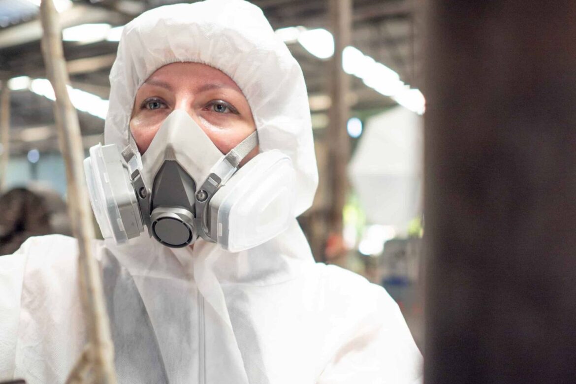Occupational hygiene specialist in full PPE during asbestos training in South Africa, ensuring compliance with safety regulations and exposure control.