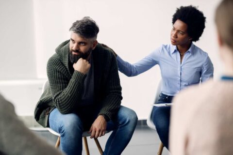 Men’s health in the workplace discussion showing a man receiving support during a workplace wellbeing or mental health session